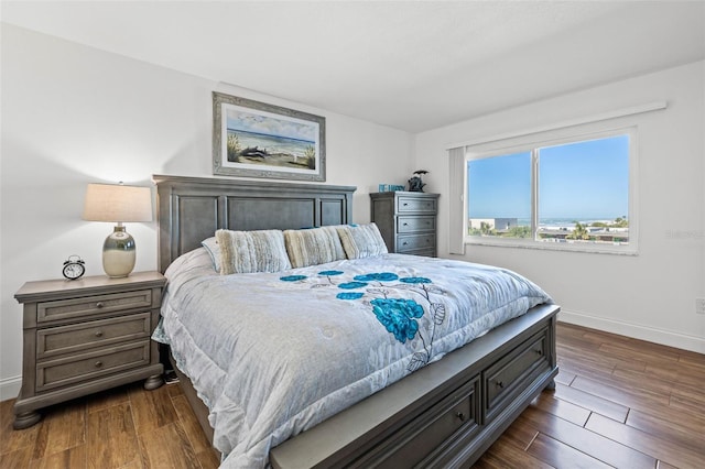 bedroom featuring baseboards and dark wood-style flooring