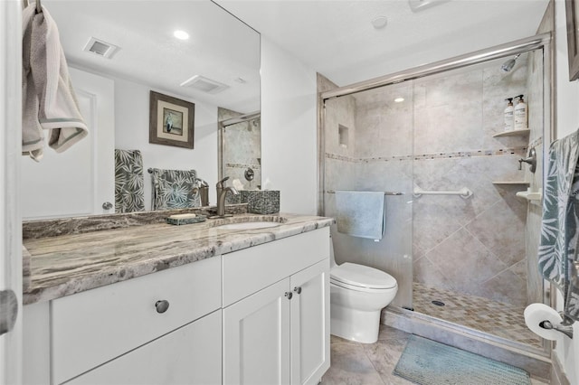 full bathroom featuring vanity, toilet, visible vents, and a stall shower