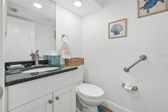 bathroom featuring visible vents, baseboards, toilet, recessed lighting, and vanity