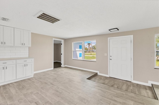 interior space with a textured ceiling and light hardwood / wood-style flooring