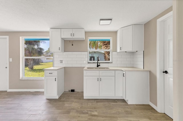 kitchen featuring a textured ceiling, white cabinetry, sink, and plenty of natural light