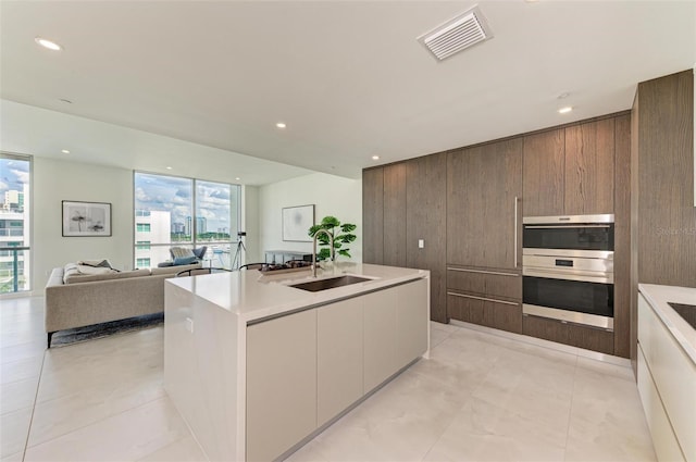 kitchen featuring light countertops, modern cabinets, a sink, and visible vents