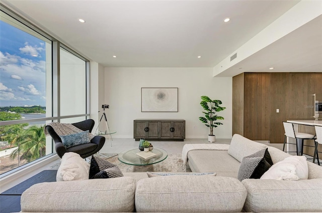 living area with recessed lighting, floor to ceiling windows, plenty of natural light, and visible vents