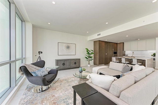 living room with concrete floors, visible vents, and recessed lighting