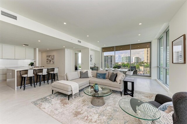 111 Golden Gate Pt Unit 402, Sarasota, FL 34236 - living area with light tile patterned floors, healthy amount of natural light, a wall of windows, and recessed lighting