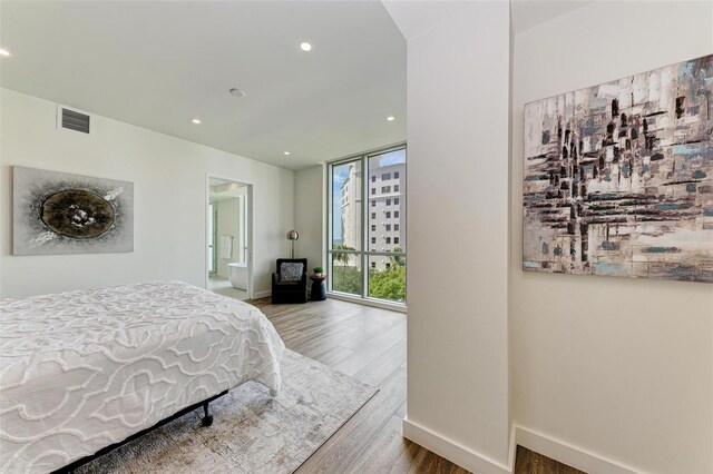 111 Golden Gate Pt Unit 402, Sarasota, FL 34236 - bedroom featuring wood finished floors, baseboards, recessed lighting, and ensuite bathroom