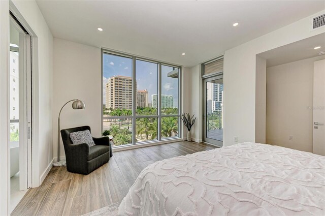 111 Golden Gate Pt Unit 402, Sarasota, FL 34236 - bedroom featuring access to outside, wood finished floors, recessed lighting, a wall of windows, and a view of city