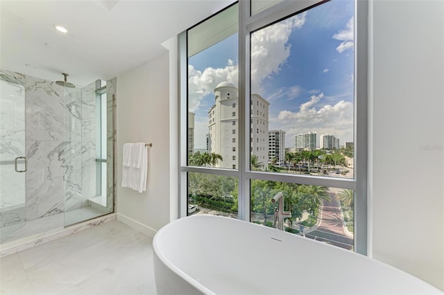 bathroom with recessed lighting, a city view, baseboards, a soaking tub, and a marble finish shower