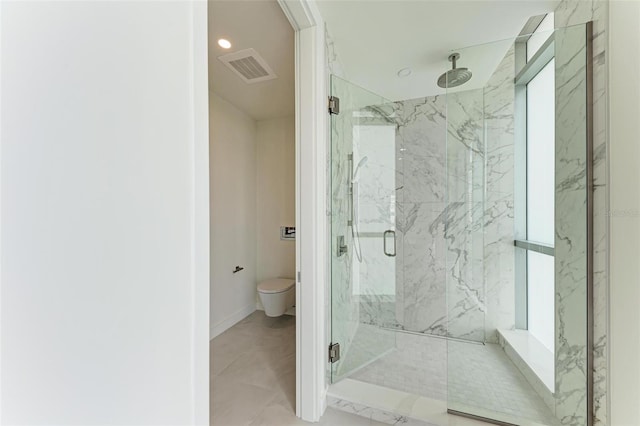 bathroom featuring baseboards, visible vents, toilet, and a marble finish shower