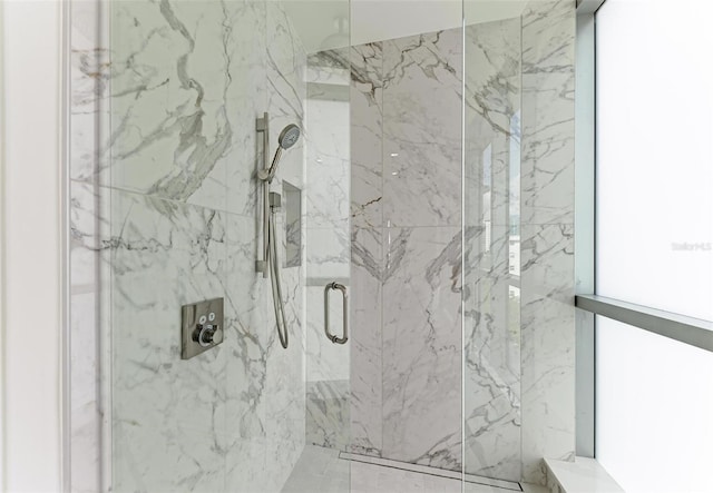 bathroom featuring a marble finish shower