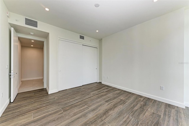 111 Golden Gate Pt Unit 402, Sarasota, FL 34236 - unfurnished bedroom with wood finished floors, baseboards, a closet, and recessed lighting