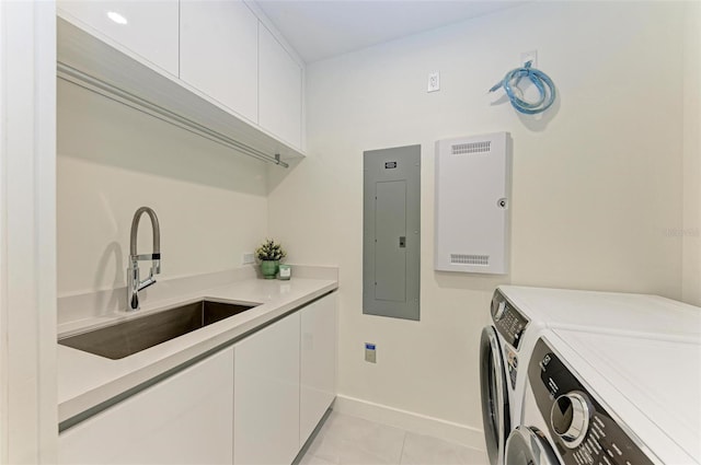 laundry area featuring light tile patterned flooring, washing machine and dryer, a sink, cabinet space, and electric panel