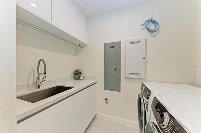 111 Golden Gate Pt Unit 402, Sarasota, FL 34236 - laundry area featuring electric panel, washing machine and clothes dryer, cabinet space, baseboards, and light tile patterned floors