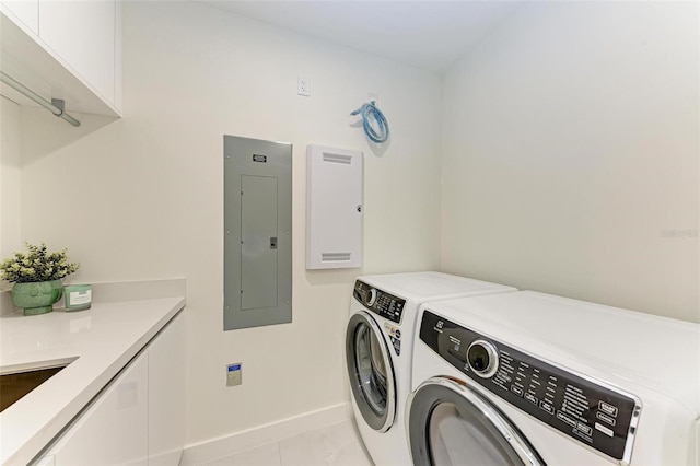 clothes washing area featuring light tile patterned floors, cabinet space, separate washer and dryer, electric panel, and baseboards