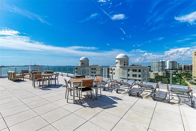 view of patio / terrace featuring a water view and a view of city