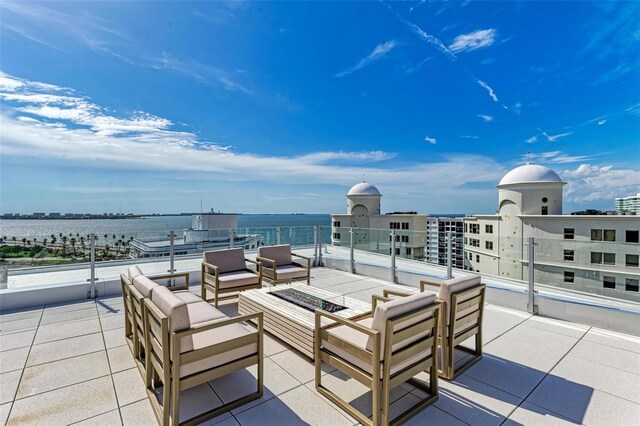 111 Golden Gate Pt Unit 402, Sarasota, FL 34236 - view of patio with an outdoor living space with a fire pit and a water view