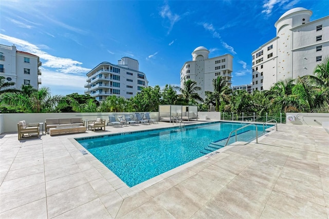 pool featuring a patio area, fence, and an outdoor living space