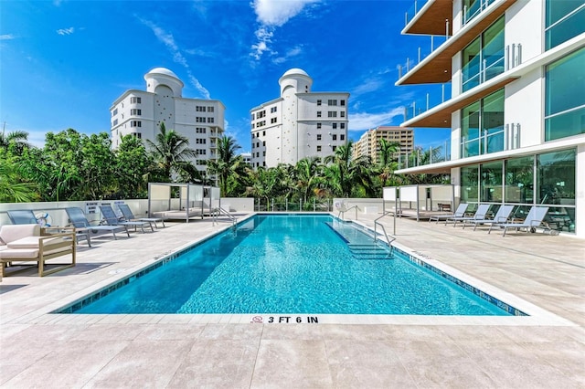 community pool with fence and a patio