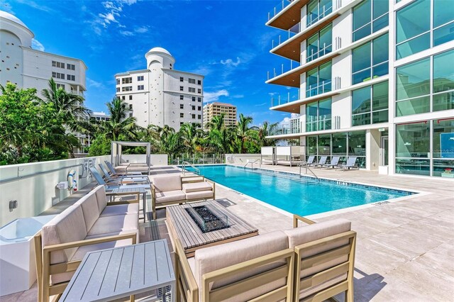 111 Golden Gate Pt Unit 402, Sarasota, FL 34236 - community pool featuring an outdoor living space with a fire pit and a patio