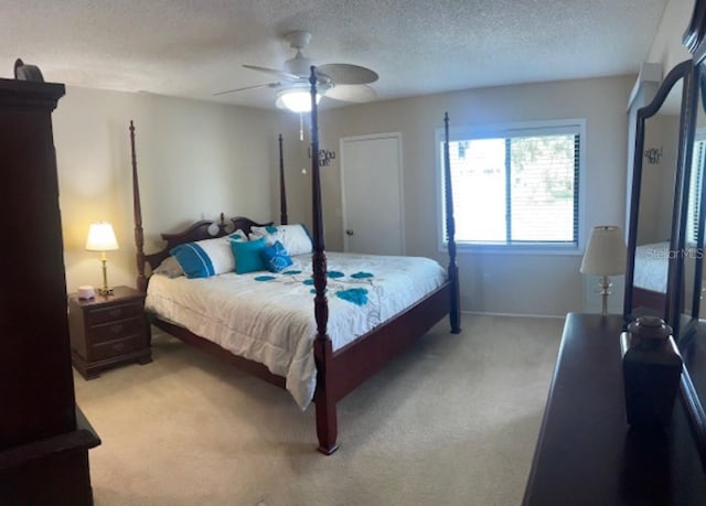 carpeted bedroom with ceiling fan and a textured ceiling