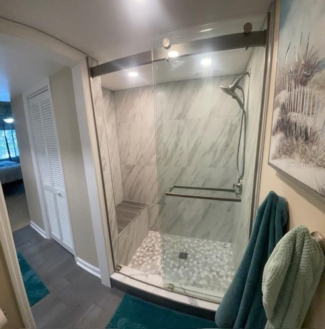 bathroom with hardwood / wood-style floors and a shower with shower door