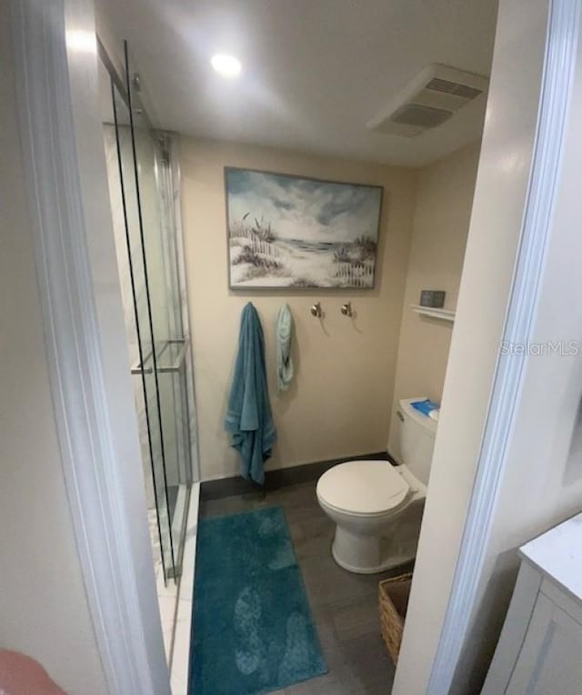 bathroom with toilet, vanity, and wood-type flooring