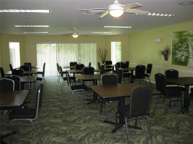 carpeted dining space featuring ceiling fan