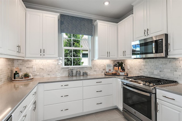 kitchen featuring white cabinets, decorative backsplash, light tile patterned flooring, and stainless steel appliances