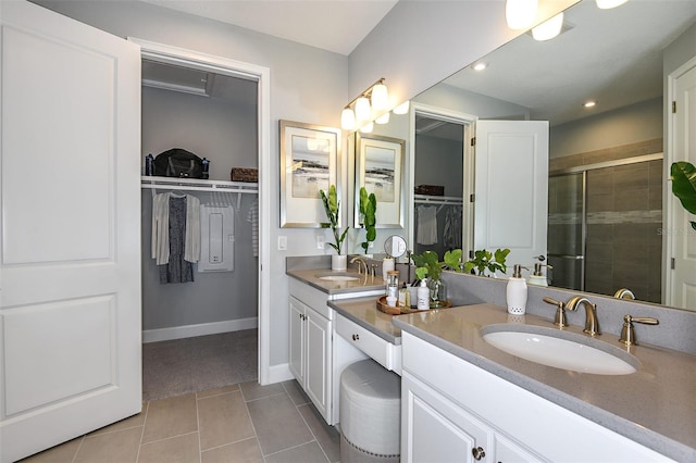 bathroom featuring tile patterned flooring, vanity, and a shower with door