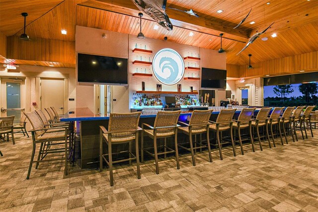 bar with decorative light fixtures, beam ceiling, a towering ceiling, and wooden ceiling