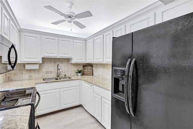 kitchen with backsplash, sink, black appliances, light hardwood / wood-style floors, and white cabinetry