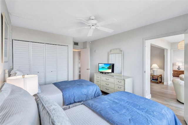 bedroom featuring light wood-type flooring, a closet, and ceiling fan