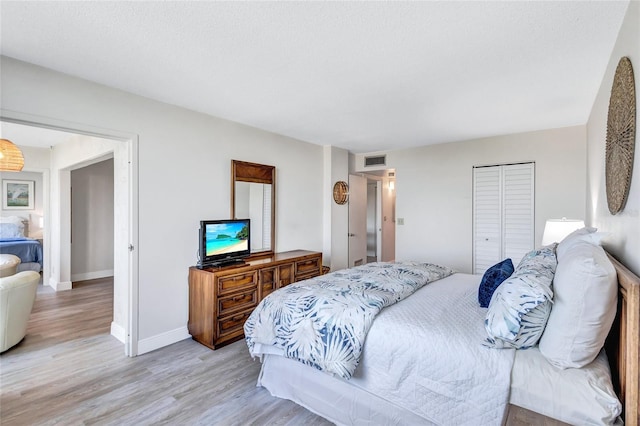 bedroom with a closet and light hardwood / wood-style flooring