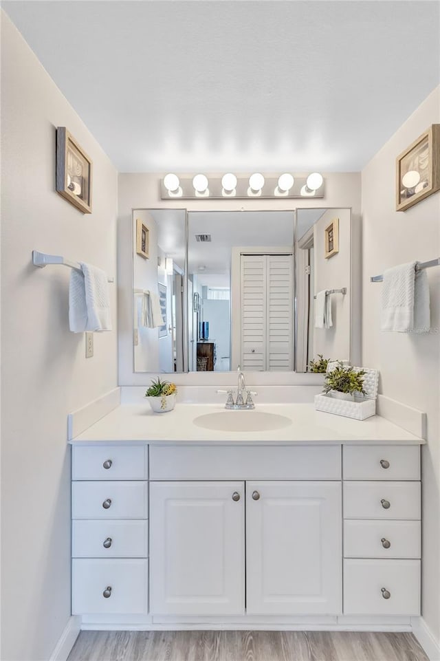 bathroom with hardwood / wood-style floors and vanity