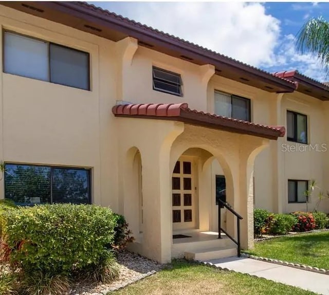 1446 56th St W Unit 1446, Bradenton, FL 34209 - view of front of property with stucco siding, a tiled roof, and a front yard