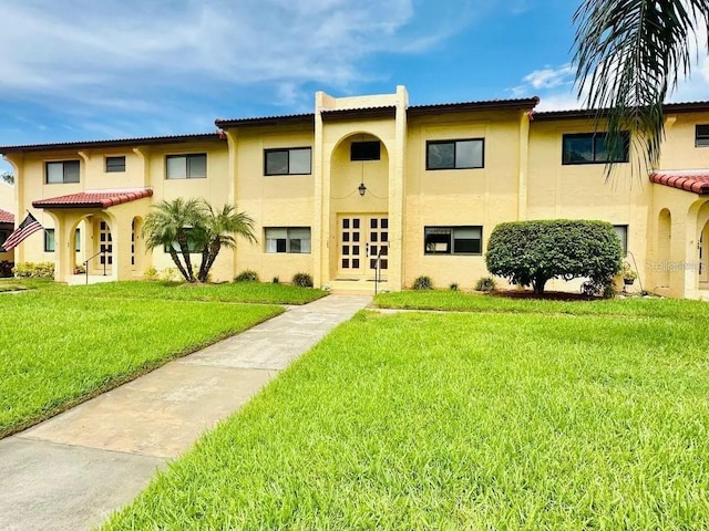 1446 56th St W Unit 1446, Bradenton, FL 34209 - view of front of property featuring stucco siding, a front yard, french doors, and a tiled roof