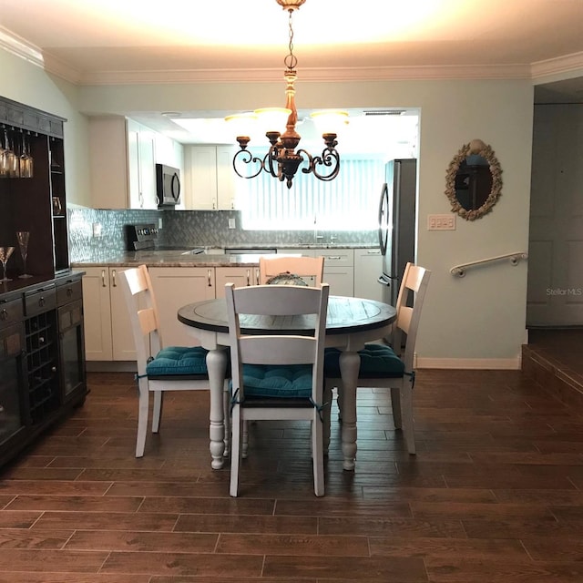 dining room with dark hardwood / wood-style flooring, an inviting chandelier, and ornamental molding