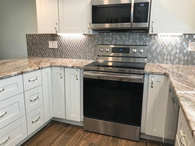 kitchen featuring white cabinets, dark hardwood / wood-style floors, tasteful backsplash, light stone counters, and stainless steel appliances