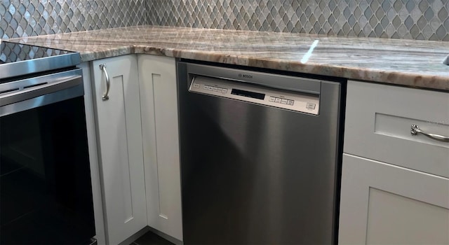 kitchen featuring white cabinets, backsplash, stainless steel appliances, and light stone countertops