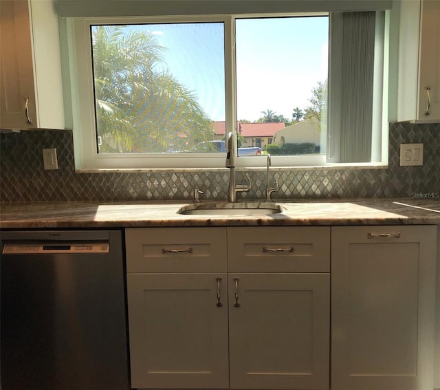 kitchen with tasteful backsplash, dishwasher, white cabinets, and sink