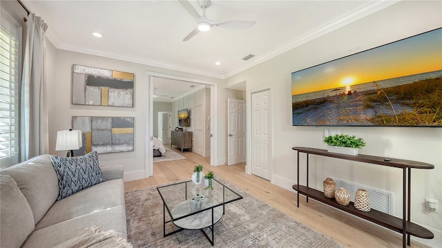 living room with light wood-type flooring, ceiling fan, and crown molding