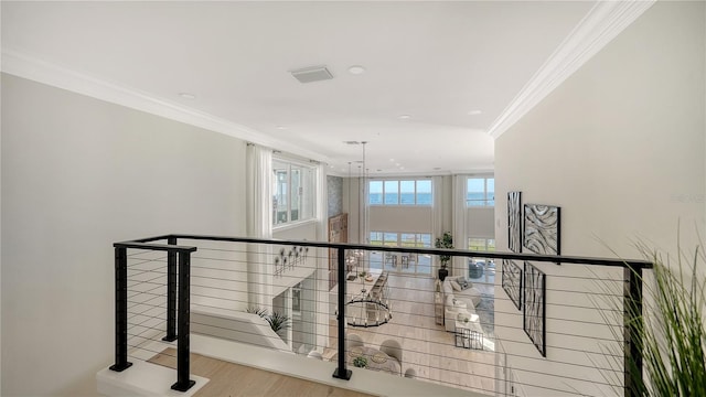 hallway with light hardwood / wood-style flooring and ornamental molding