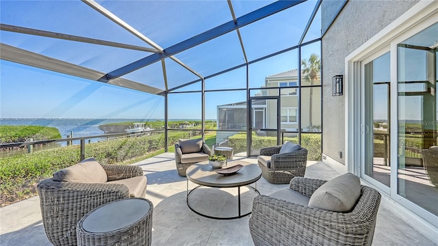 view of patio / terrace featuring an outdoor living space, a water view, and a lanai