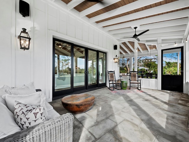 sunroom with ceiling fan and beamed ceiling