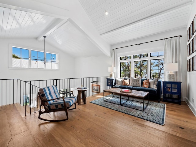 sitting room with hardwood / wood-style floors, vaulted ceiling with beams, and a healthy amount of sunlight