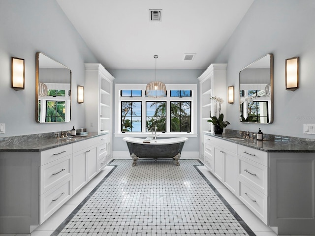 bathroom featuring tile patterned flooring, a washtub, and vanity