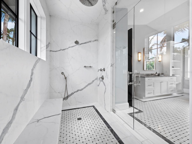 bathroom with a tile shower and vanity