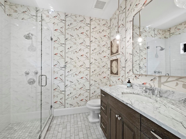 bathroom featuring vanity, toilet, and a shower with door