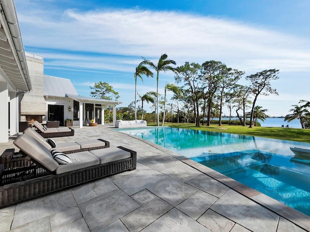 view of pool featuring an outdoor living space, a water view, and a patio