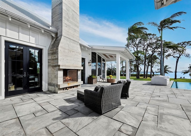 view of patio featuring french doors and an outdoor fireplace